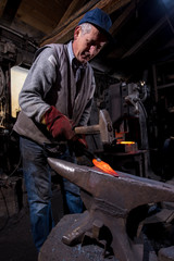 Wall Mural - blacksmith manually forging the molten metal