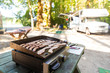 Bacon and Sausage cooking on a camp grill
