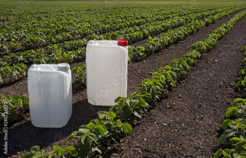 Fotografía Canisters with pesticides in field