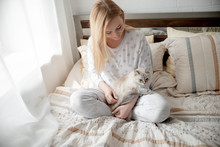 Blonde Giirl Hygge With Fluffy Cat, Pajama And Blanket. Hugge And Lagom Concept Comfort And Simple Life . Horizontal Copyspace