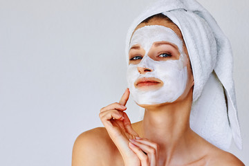 Wall Mural - beautiful woman applying facial mask on her face. skin care and treatment, spa, natural beauty and c