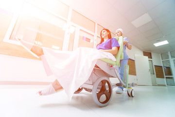 Wall Mural - Nurse moves mobile medical chair with patient at hospital. Medical equipment.