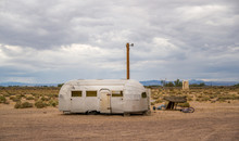 A Air Stream Like Trailer Is Parked In The Desert Of California
