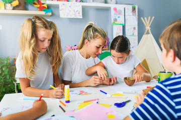 Wall Mural - Mother or school teacher with children. Creative arts and crafts project at school or at home.