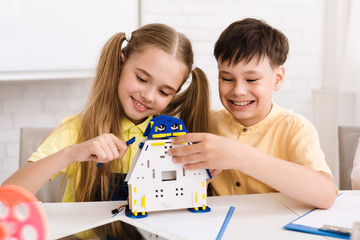 Happy kids constructing robotic toy at stem class