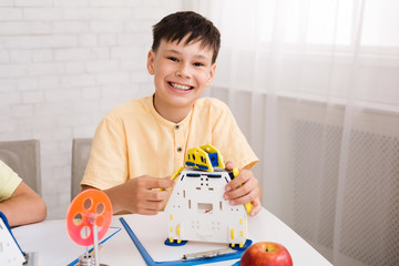 Poster - Smart boy constructing robot and smiling to camera