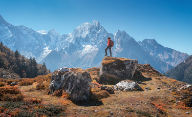 Wall Mural - standing woman with backpack on the stone and beautiful mountains at sunset. landscape with sporty g