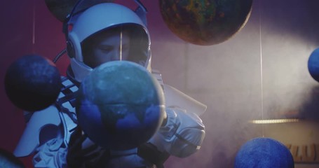 Wall Mural - Student in space suit revolving planet model