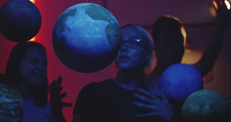 Wall Mural - Young teacher teaching astronomy with planet models