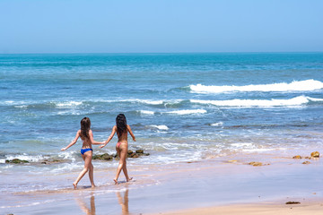 Traveling tourist girls enjoying their summer on the beach