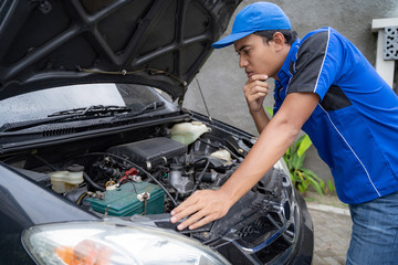 home service mechanic doing some inspection on car's engine