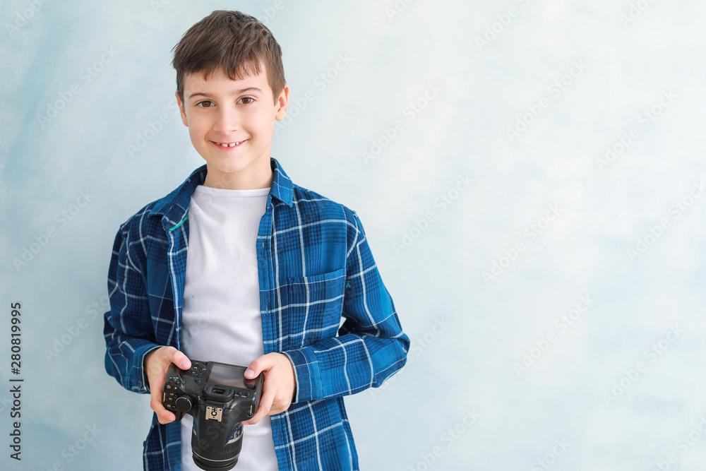 Cute little photographer on color background