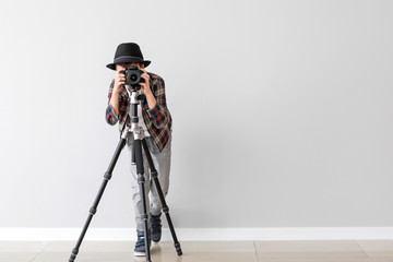 Wall Mural - Cute little photographer near white wall