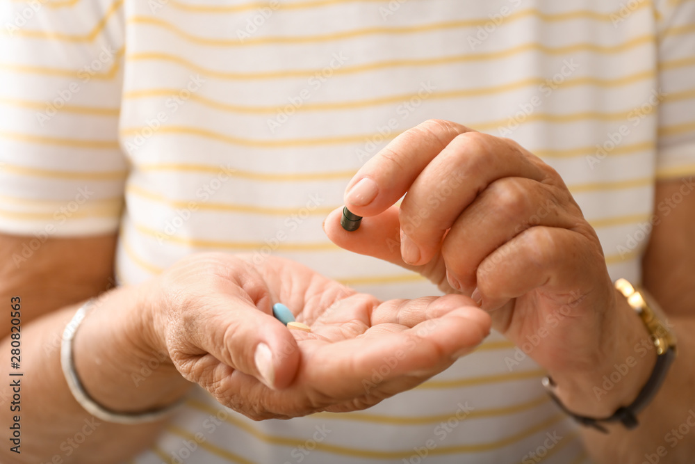 Elderly woman with pills, closeup