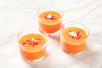 Salmorejo, Spanish cold tomato soup, in glasses on a white marble background with a place for text