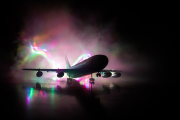 Artwork decoration. White passenger plane ready to taking off from airport runway. Silhouette of Aircraft during night time.