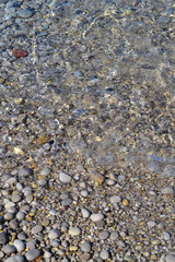 Wall Mural - Sea stones in the sea water. Pebbles under water. The view from the top. Nautical background. Clean sea water. Transparent sea.