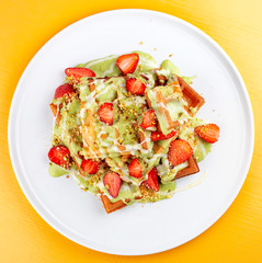 Wall Mural - Belgian waffles with pistachio cream topping and strawberries