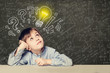 © artmim - Idea! Smart kid student with lightbulb on blackboard