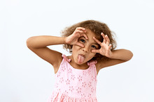 Making Face,funny  Foolishes Portrait Of Little African American Girl, Against White Background.