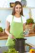 © rogerphoto - Young happy woman cooking soup in the kitchen. Healthy meal, lifestyle and culinary concept. Smiling student girl preparing vegetarian meal at home
