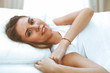 © rogerphoto - Beautiful young and happy woman sleeping while lying in bed comfortably and blissfully smiling