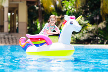 Child On Unicorn Float In Swimming Pool. Kids Swim