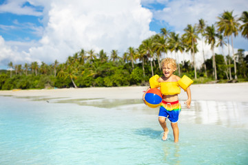 Wall Mural - Kids play on tropical beach. Sand and water toy.