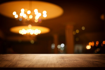 Wall Mural - Image of wooden table in front of abstract blurred restaurant lights background