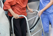 Elderly Female Using Walker While Get Out Of Car With Caregiver