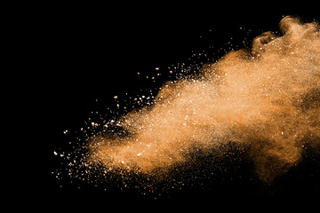 Wall Mural - Abstract brown powder explosion. Closeup of brown dust particle splash isolated on black background