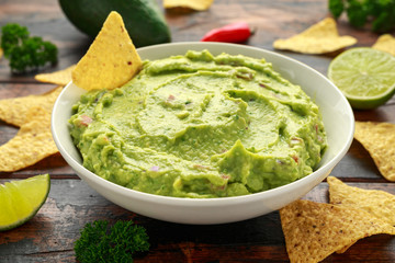 Wall Mural - Bowl of fresh Guacamole with nachos chips and herbs. Healthy Vegan, Vegetables food.