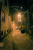 Fototapeta Uliczki - Dark and scary vintage cobblestone brick city alley at night in Chicago