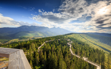 Fantastic Slovak Bachledova Dolina landscape with mountains, trial above the trees and blue sky