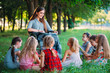 © davit85 - Disabled teacher conducts a lesson with children in nature. Interaction of a teacher in a wheelchair with students.
