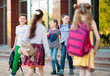 © davit85 - Schoolmates go to school. Students greet each other.