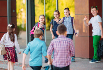 Wall Mural - Schoolmates go to school. Students greet each other.