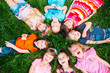 © davit85 - A group of children lying on the green grass in the Park. The interaction of the children.