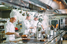Modern Kitchen. Cooks Prepare Meals On The Stove In The Kitchen Of The Restaurant Or Hotel. The Fire In The Kitchen.