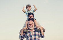 Excited. Father And Son Playing Outdoors. Happy Smiling Boy On Shoulder Dad Looking At Camera. Happy Family. Three Men Generation.