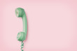 mint colored vintage phone receiver on a pink background, retro background, copyspace for your text