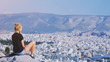 © raisondtre - Young tourist woman sitting on top of mountain and looking at a beautiful landscape cityscape Athens Greece. Adult girl tourist relax on hill overlooking Athens in summer. Famous Athens city in Europe