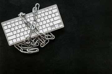 Online security system with keyboard and chain on black background top view mock up