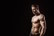 © KDdesignphoto - Muscular model sports young man on dark background. Fashion portrait of strong brutal guy with a modern trendy hairstyle. Sexy torso. Male flexing his muscles.