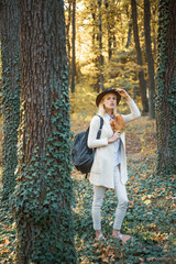 Wall Mural - Cheerful carefree autumn woman in park on sunny day. Fall concept. Surprise autumn woman. Autumn girl preparing for Autumn sale.