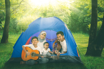 Wall Mural - Muslim family with guitars in the camping tent