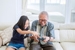 © Creativa Images - Old man playing video games with his granddaughter