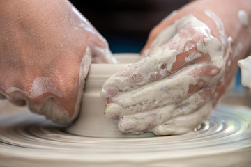 Potter makes pottery dishes on potter's wheel