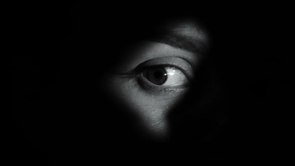concentrated female looking around through hole, trapped victim planning escape