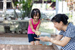 Leinwandbild Motiv Asian Little Chinese Girl and mother playing wirh duck